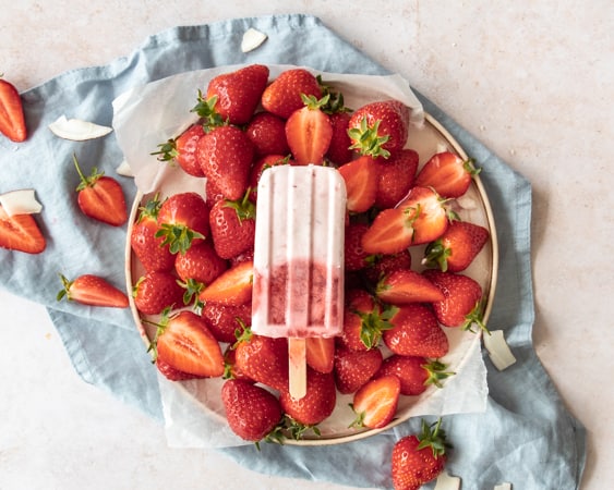 Eton Mess Ice Lolly with Coconut Cream on a plate with strawberry and coconut  