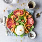 Panzanella salad recipe with melon tomato and burrata on a plate with oilve oil drops