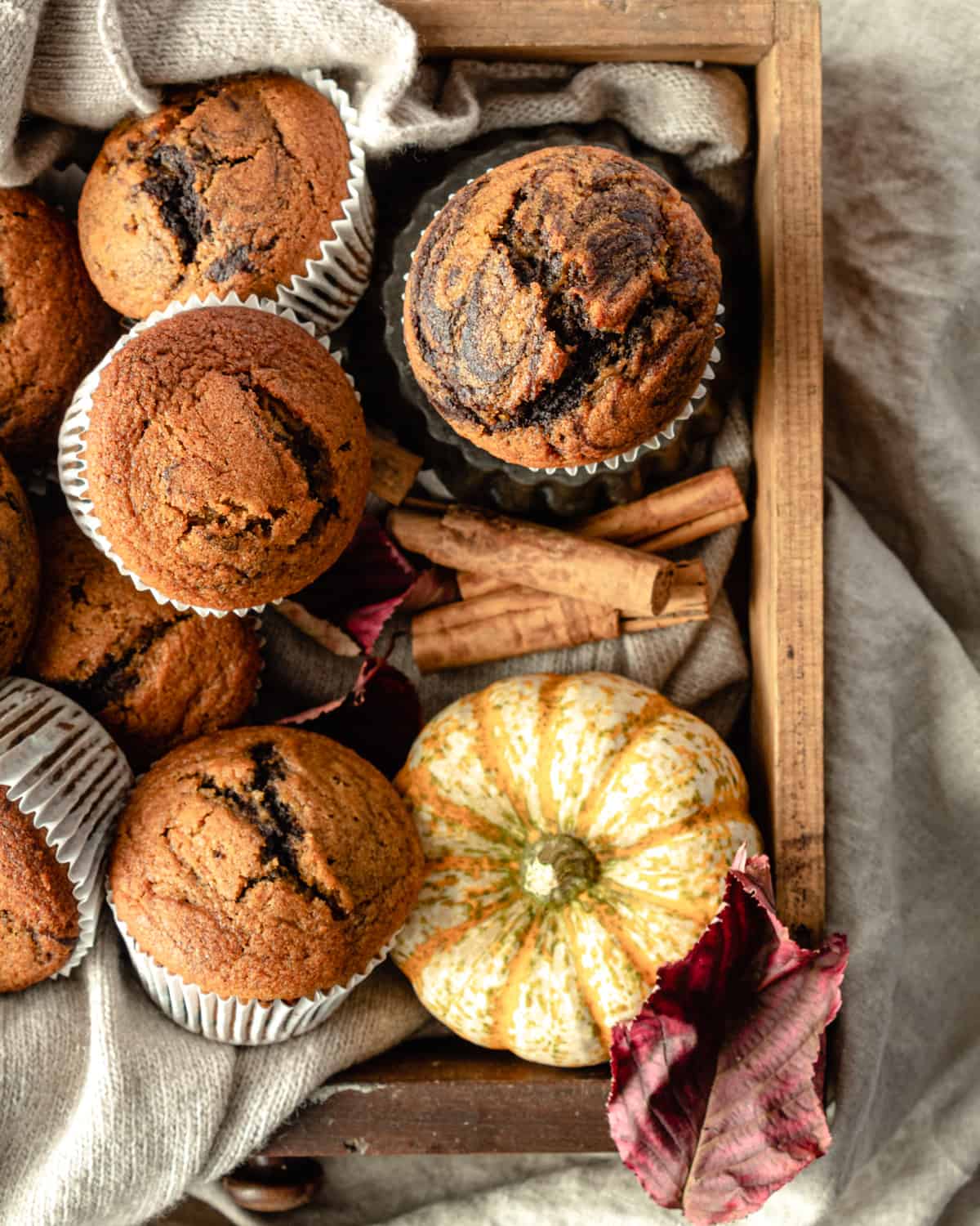 Close up Muffins on a wood box with cinnamon and pumpkin and wool cloth around 