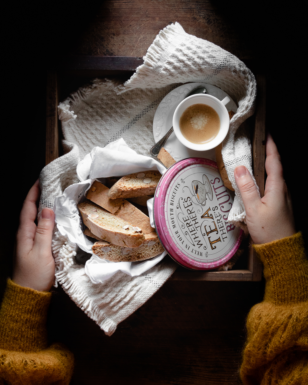 Hands holding a tray with biscotti 