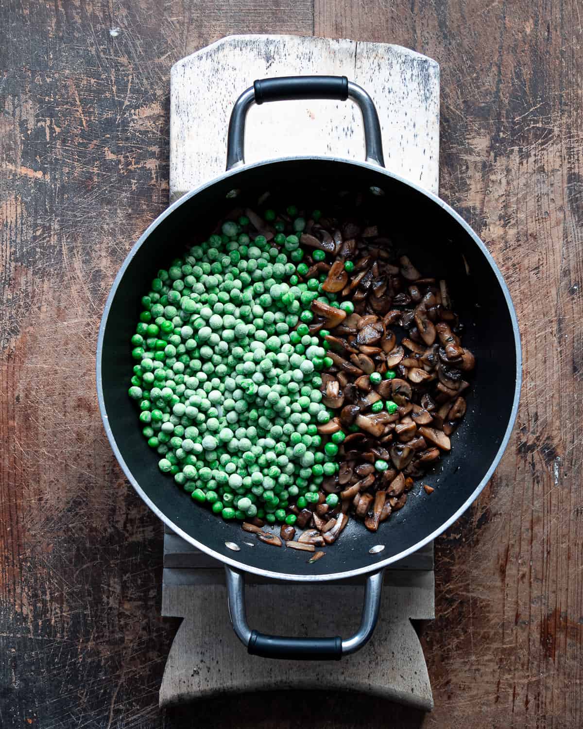  Sauteed mushrooms with peas on a frying pan
