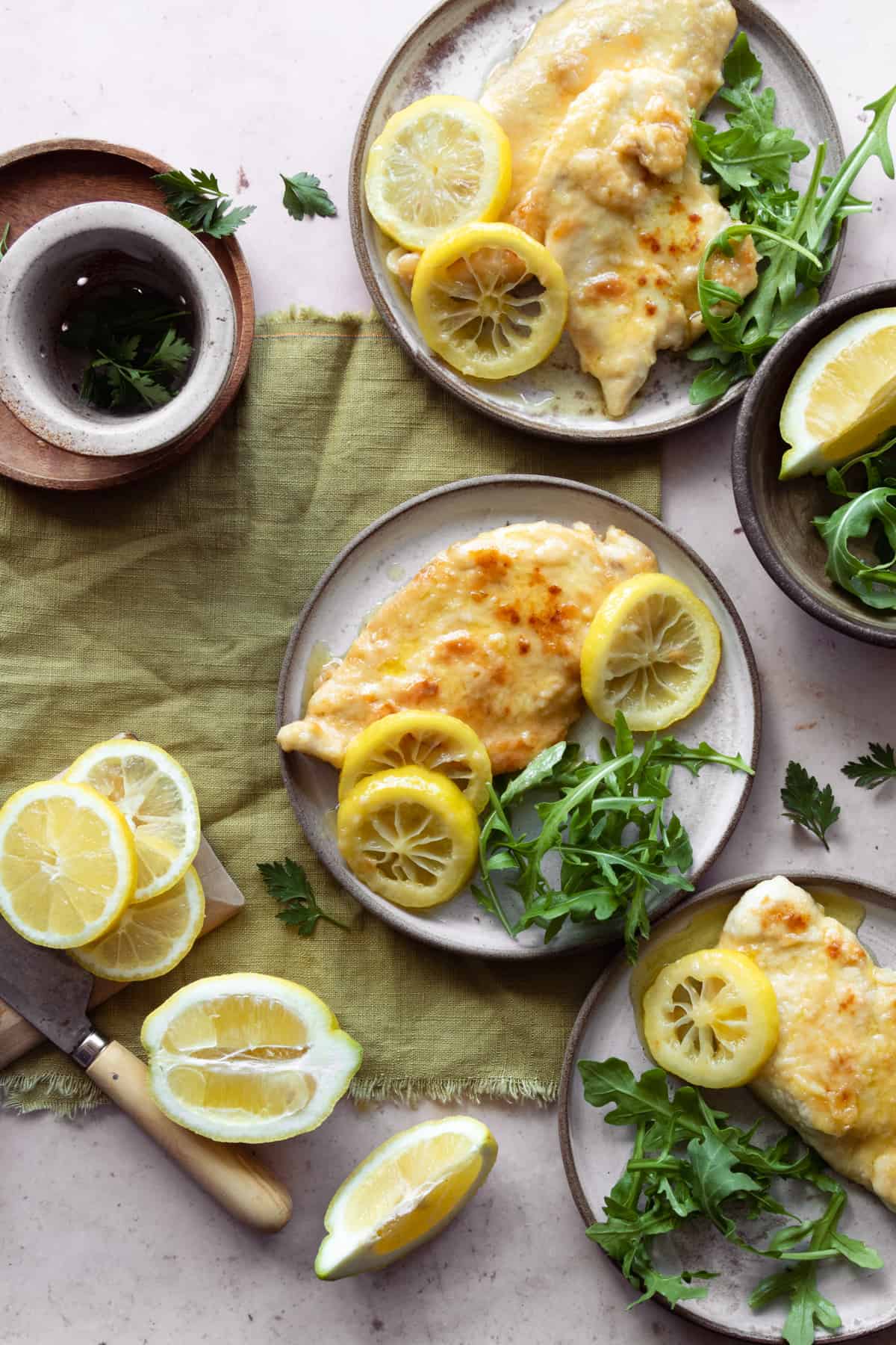 Ready chicken piccata al limone recipe on plates with arugula on the side. 
