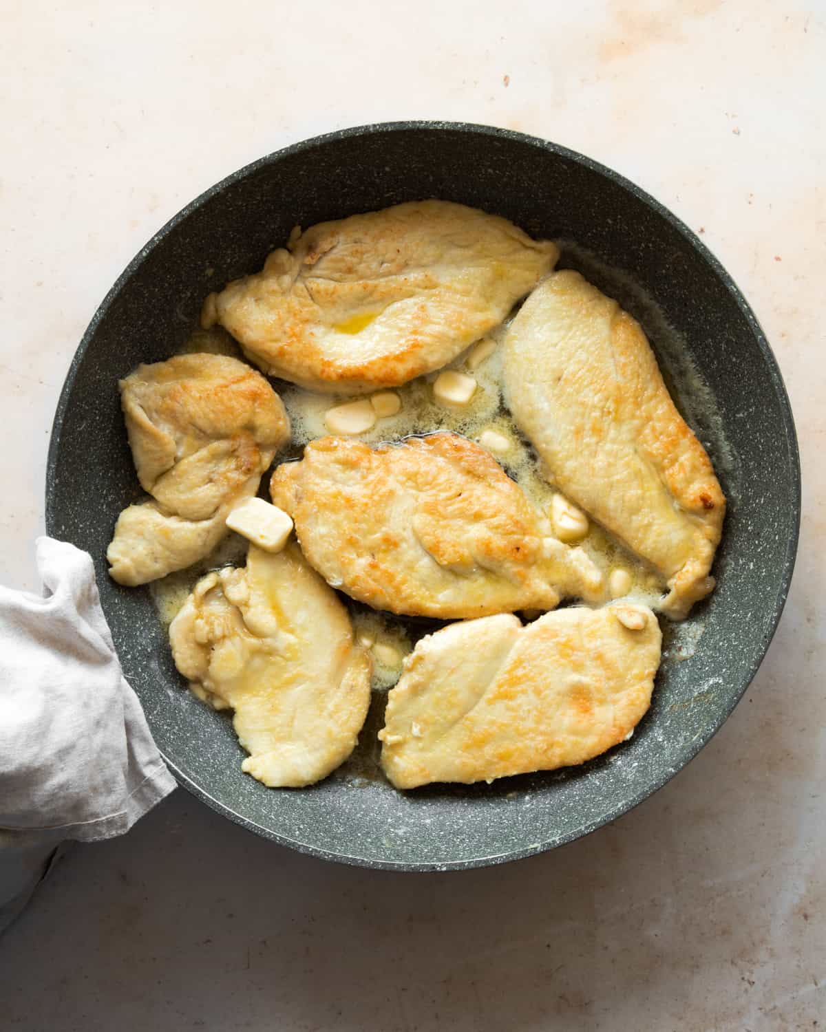 Cutles in a frying pan with some butter.