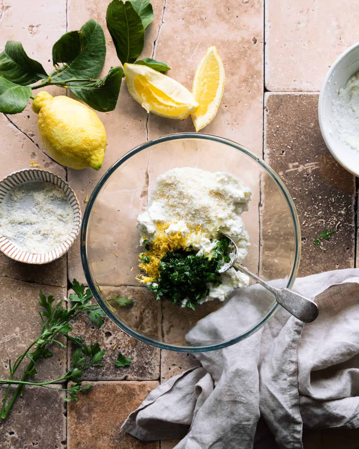 Bowl with ricotta, lemon, parsley, cheese ready to be whisked. 