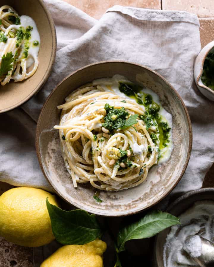 One post pasta wih ricotta on a bowl near some lemons and a ricotta bowl