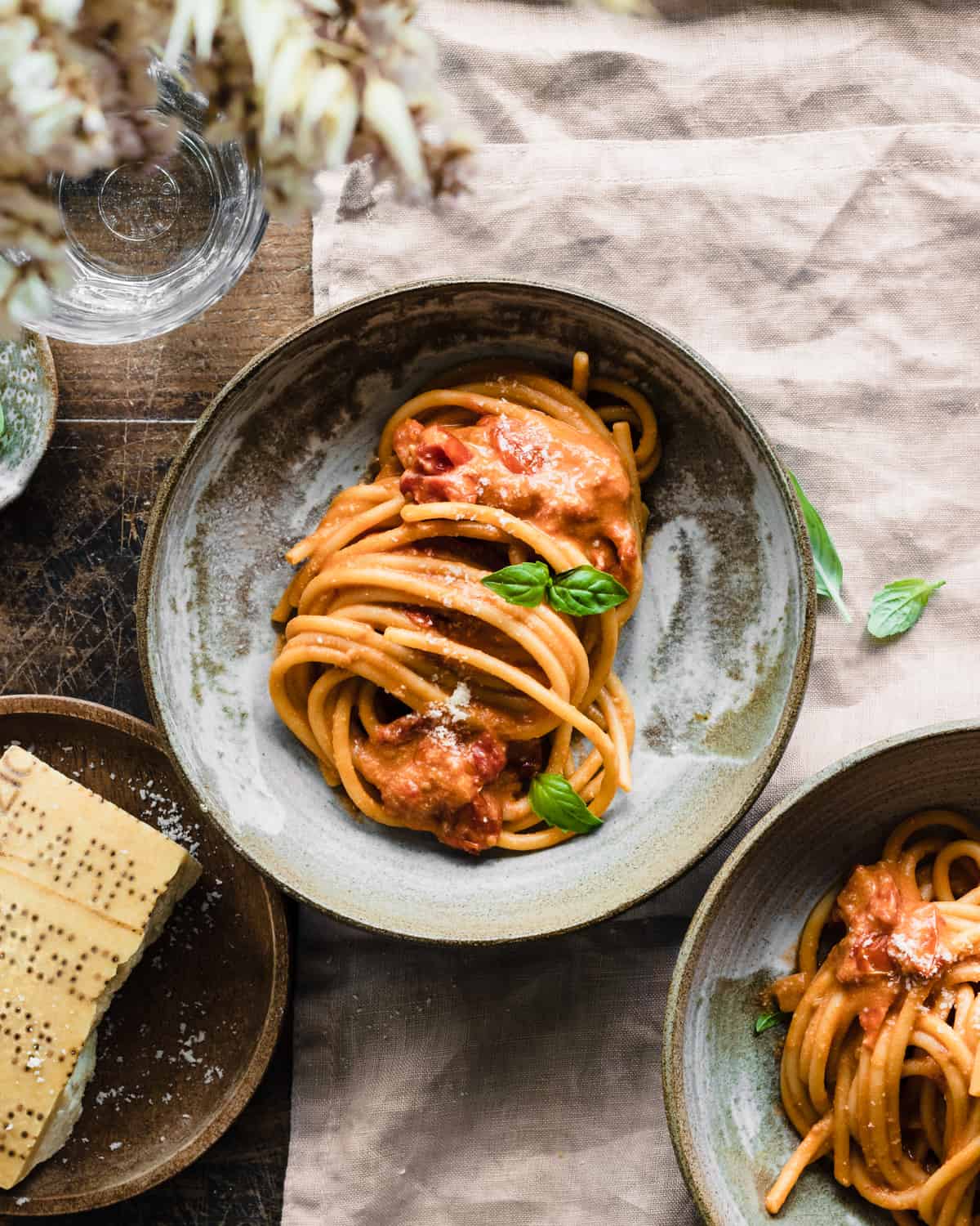 Two bowls with some pink pasta sauce recipe and a basil leaf on top.