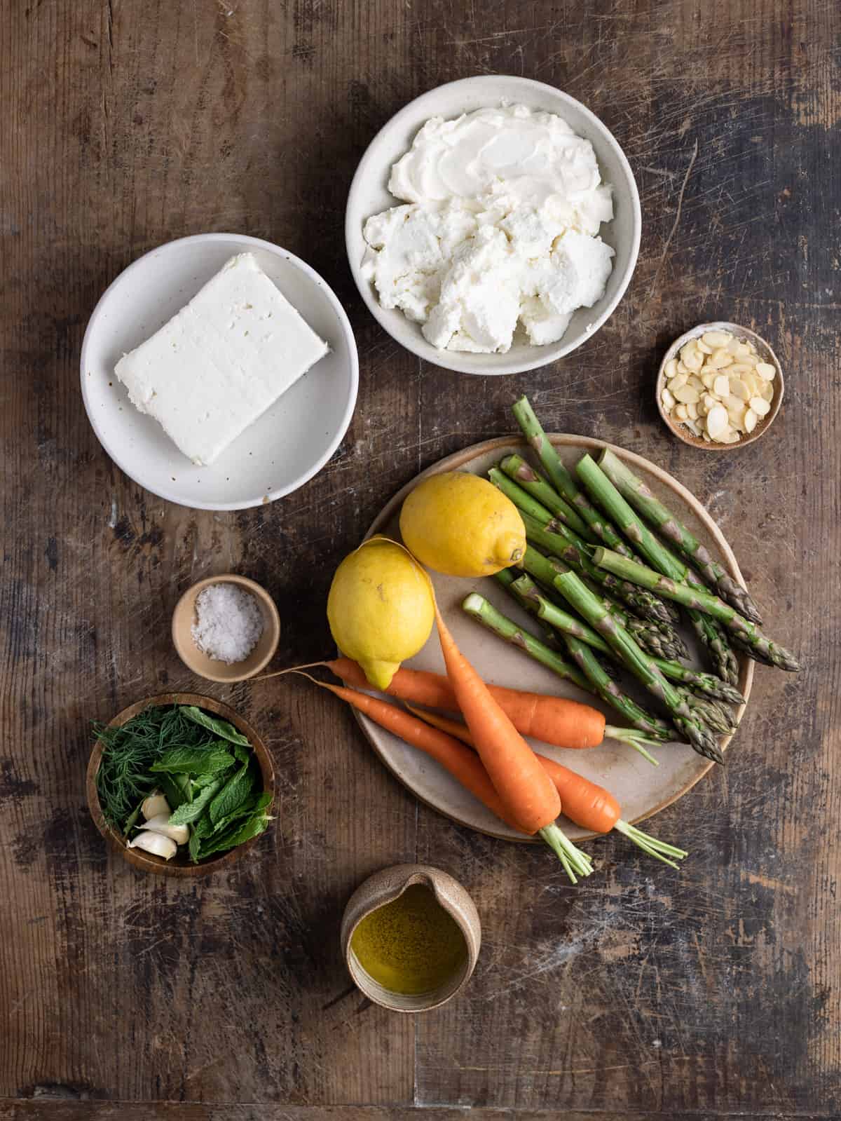 Overhead shot of ingredients in bowls and plate on a wooden table.