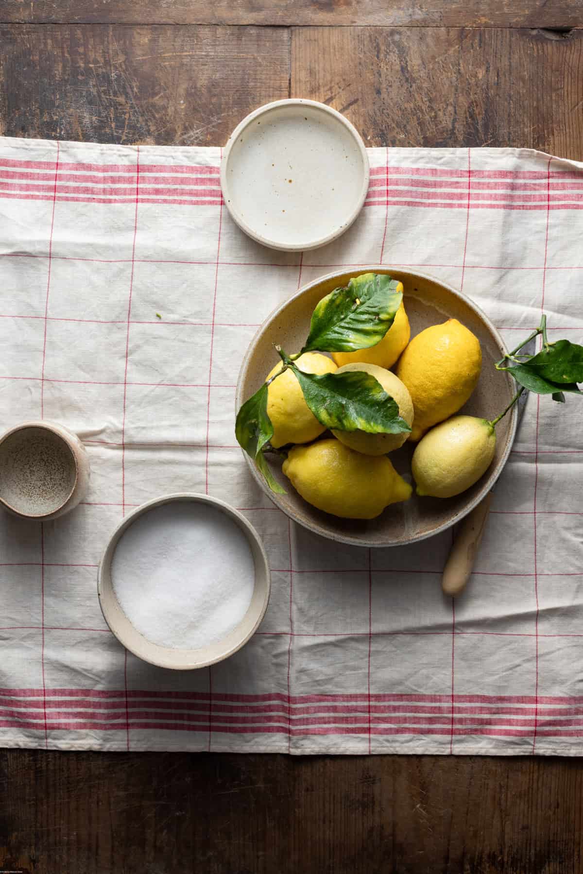 Ingredients placed on different bowls on a wooden table.