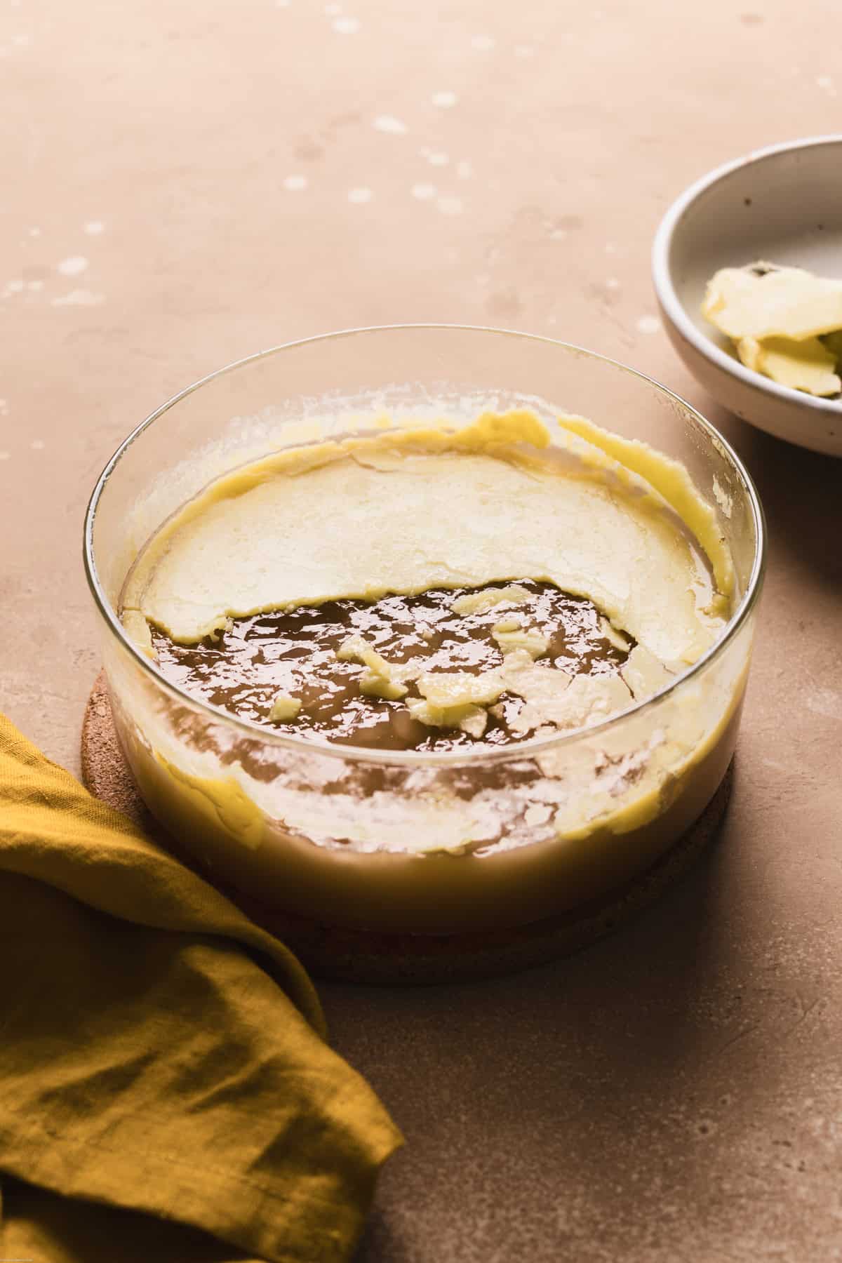 photo showing the broth in a glass container with the layer of fat
