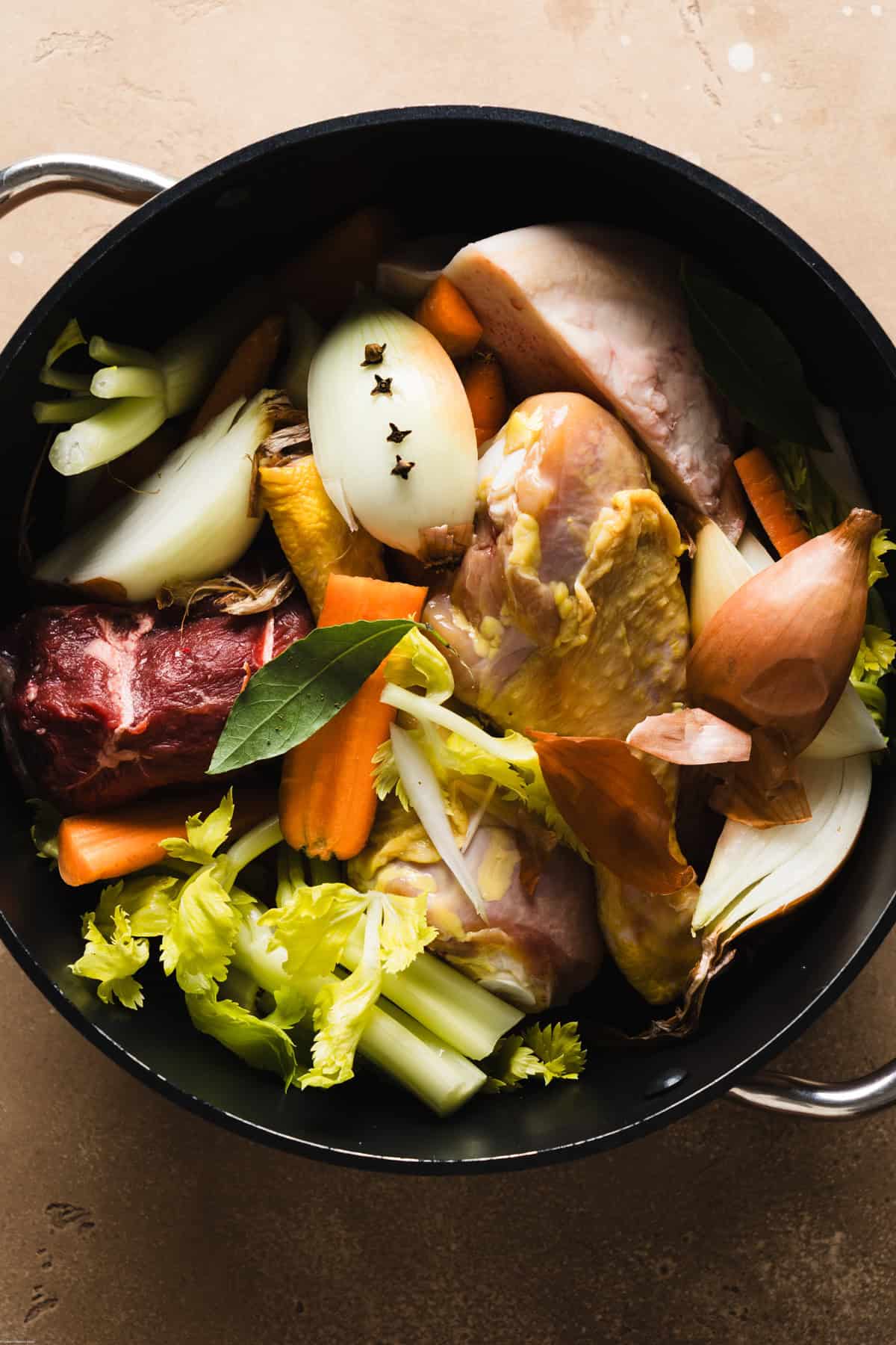 a photo showing a process step of large pot filled with all the ingredients to make the stock